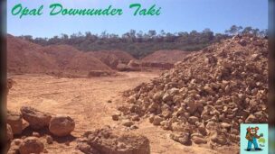ボルダーオパール鉱山の採掘現場。掘り上げられた赤茶色の岩の山と、奥で作業する重機
